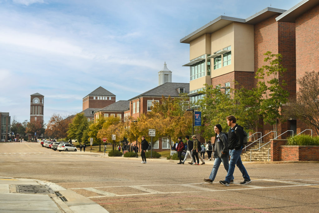 Two students walk in a crosswalk on Louisiana Tech's campus with the Tech Pointe I building in the background