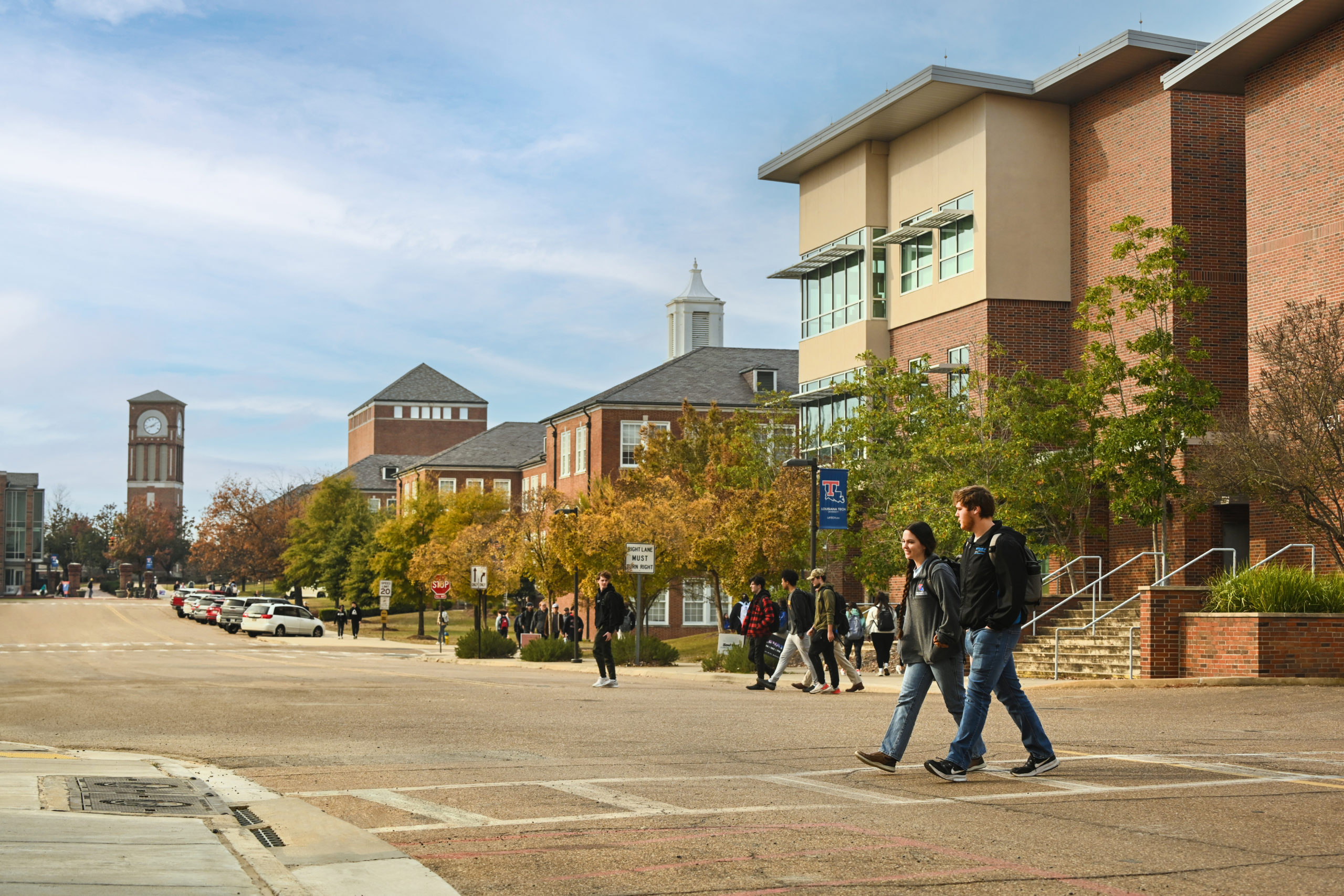 Two students walk in a crosswalk on Louisiana Tech's campus with the Tech Pointe I building in the background